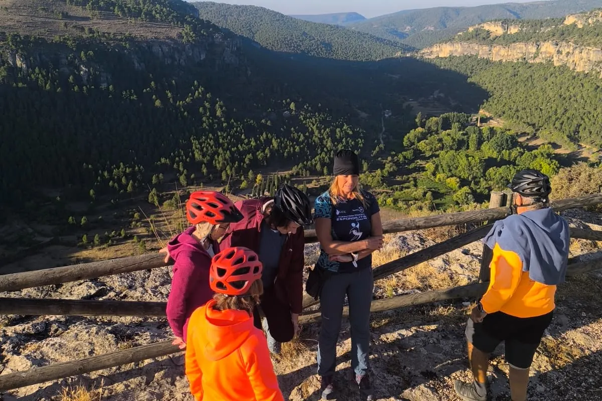 Participantes con casco junto a la barandilla de madera de un mirador