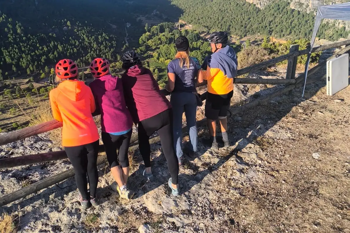 Grupo de participantes con casco contempla el valle desde un mirador