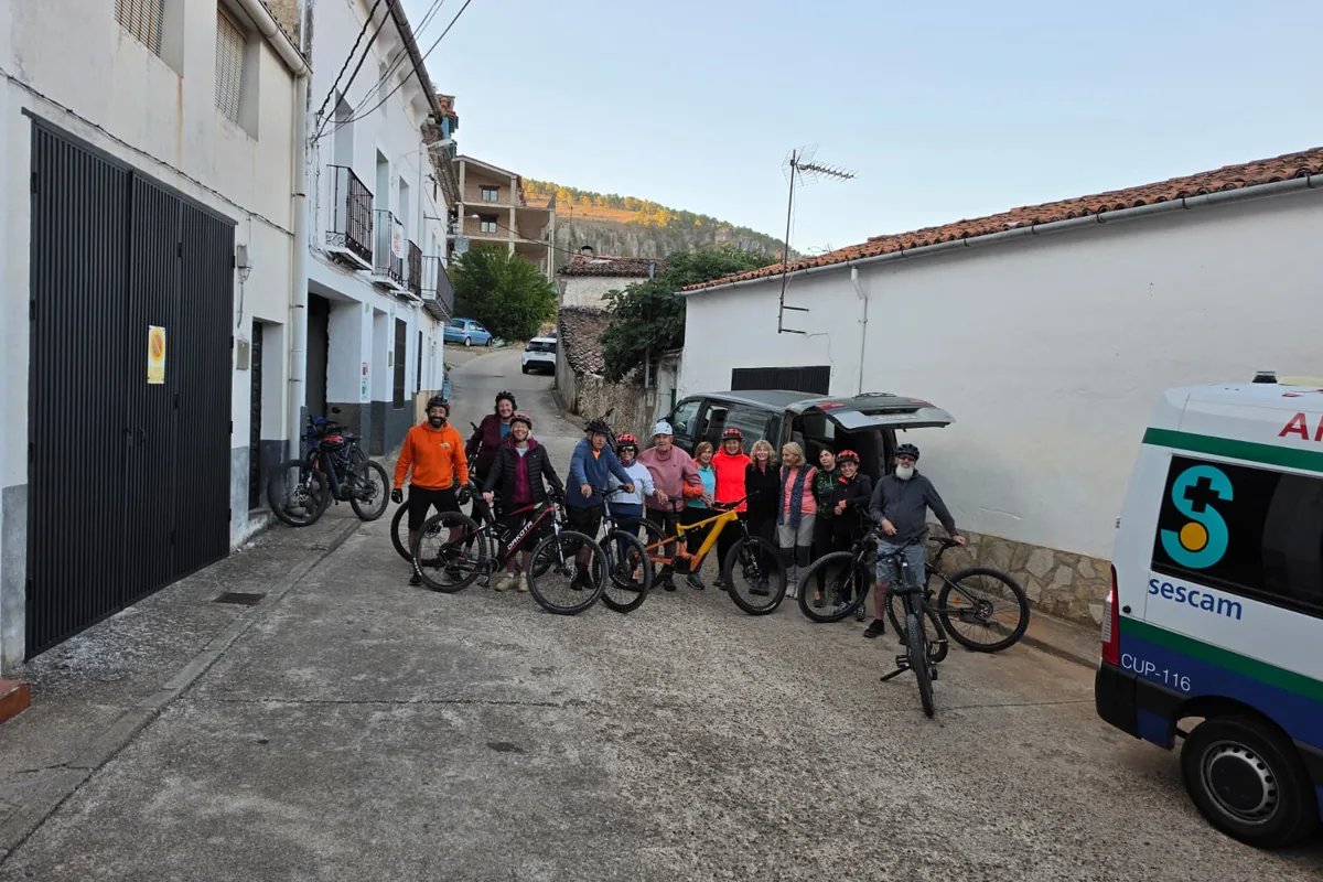 Grupo con bicicletas eléctricas reunido en una calle del pueblo antes de salir